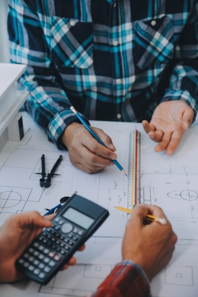 engineer people meeting working and pointing at a drawings in office for discussing. Engineering tools and construction concept.